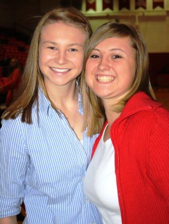 Guitarist Makayla Keene, left and poet Kelsey Grubbs share a hug